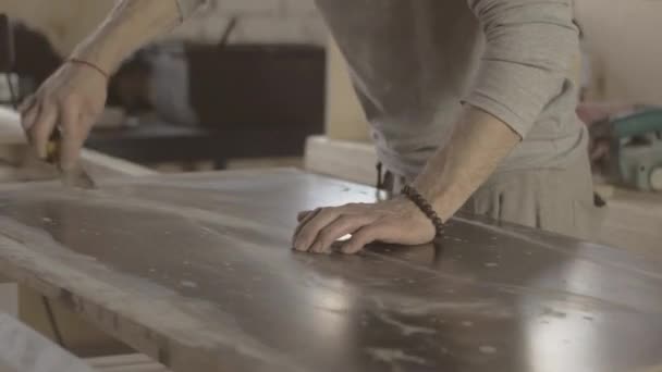 Trabajador de la madera rasca la superficie de tablero de madera por raspador handware. Fabricante — Vídeo de stock