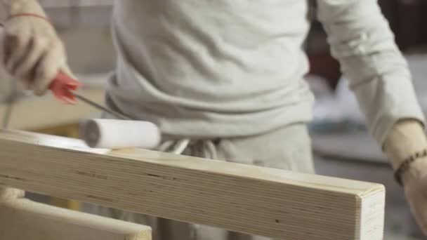 Tischler lackiert die Oberfläche der Holzplatte mit der Farbrolle. Prozessbehandlung — Stockvideo