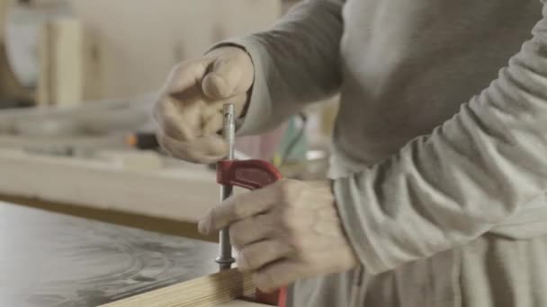 Carpentiere professionista che fissa tavola di legno da morsetti metallici. Fare mobili — Video Stock