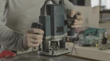 Profesyonel marangoz ahşap tahta kenarına dalma yönlendirici koyarak.