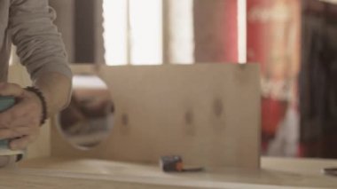 Woodworker dikkatli işlem yüzeyi ahşap tahta kemer sander tarafından yaşlı.