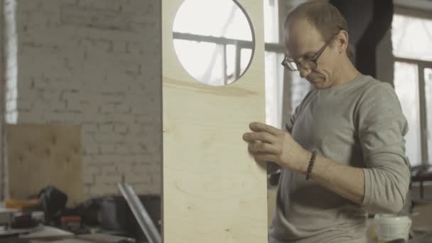 O carpinteiro profissional conecta duas placas de madeira diferentes. Processo de montagem — Vídeo de Stock