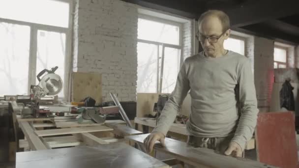 Menuisier adulte professionnel a repoussé les planches en bois polies de la table de travail .