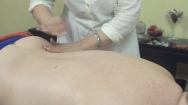 Masöz, profesyonel salonda yetişkin şişman bir kadına masaj yapıyor. Sağlık hizmetleri. Terapi. Kapat.