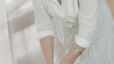 Masseuse make massage of left foot to woman in saloon, covers blanket. Therapy