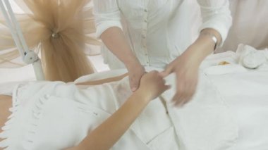 Masseuse make massage of fingers on right woman hand in beauty saloon. Therapy