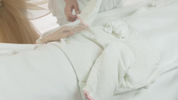 Masseuse repoussé mitaine blanche de la main de la femme dans le salon de beauté. Masque à main Thermo — Video