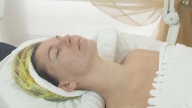 Woman face with closed eyes in beauty saloon on cosmetic procedure. Problem skin