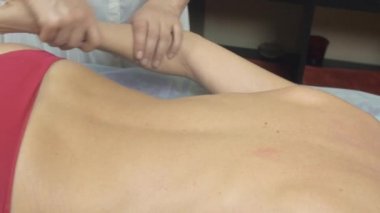 Masöz sırt iyileştirici masaj yapmak, salonda genç ince kadın omuz.