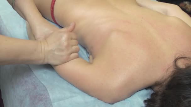 Μασέρ κάνει θεραπευτικό μασάζ του δεξιού χεριού σε λεπτή γυναίκα στο σαλούν. Θεραπεία — Αρχείο Βίντεο