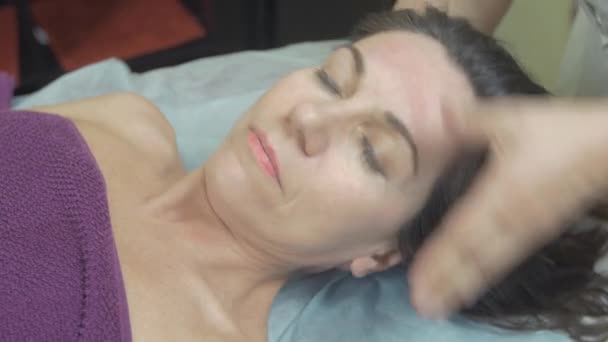 Masseuse maken genezing massage van nek naar jonge vrouw in professionele Saloon. — Stockvideo