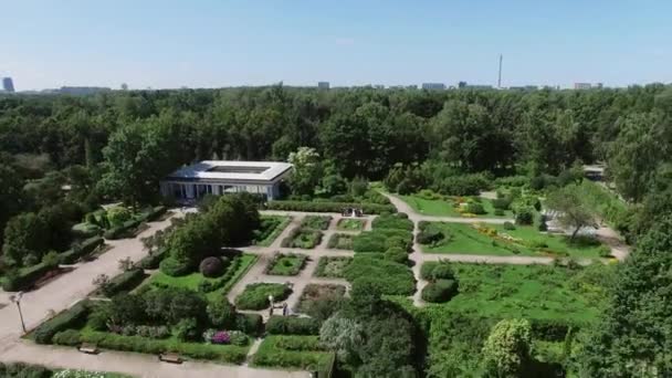 Quadrocopter střílet krásné zelené letní zahrada s fontánou v centru. Lidé mávají rukama. Slunečno — Stock video