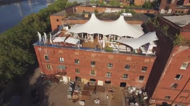 Quadrocopter schieten zomer restaurant met witte tent op het dak van gebouw op de rivier. Zonnige. Landschap — Stockvideo