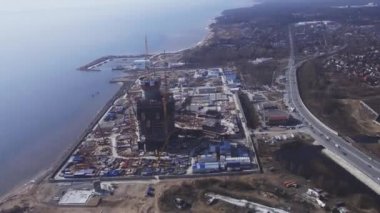 Helikopter havadan görünümden sinek sahilinde şehir üzerinde. İnşaat alanı. Nehir. Güneşli bir gün. Cityscape