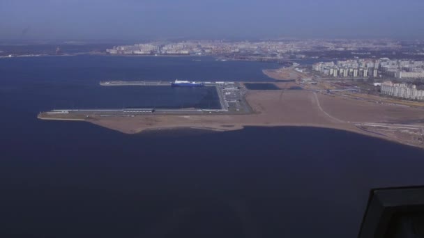 Вид з повітря з вертольота летить над водою. Пейзаж міста на узбережжі, морський порт. Сонячний день — стокове відео
