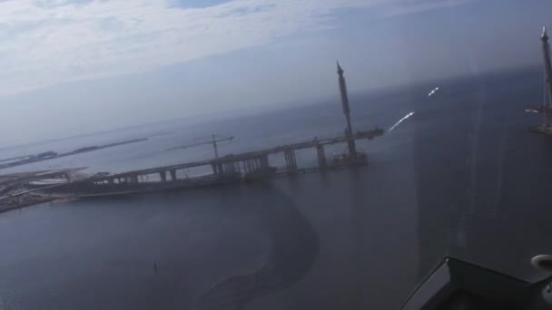 Aerial view from helicopter fly above blue water. Bridge under construction. Sunny day. Landscape — Stock Video