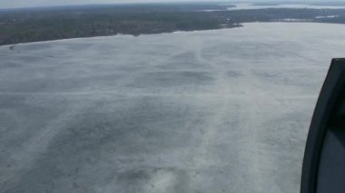Helikopter havadan görünümden uçmak yeşil orman donmuş gölde yukarıda. Kamera bünyesinde. Buzlu su yüzeyi