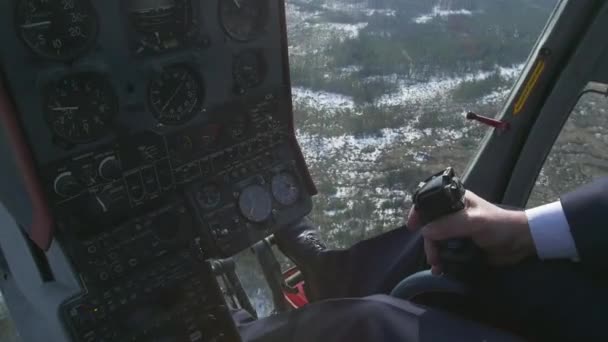 View control system pilot hold lever of helicopter. Camera in pilot cabin. Above forest. Sunny. Snow — Stock Video