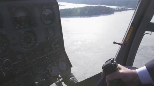 Пілот системи керування переглядом тримає важіль вертольота. Камера в пілотній кабіні. Над замерзлим озером. Сонячний — стокове відео