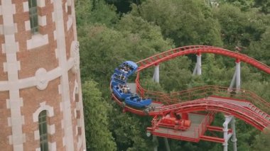 Eğlence Parkı içinde kırmızı roller coaster üzerinde insanlar. Aşırı. Yaz günü. El kaldırsın