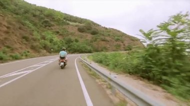 Kask insanlarda arka yüzü yeşil tepeler yolda motosiklet binmek. Seyahat. Yolculuk