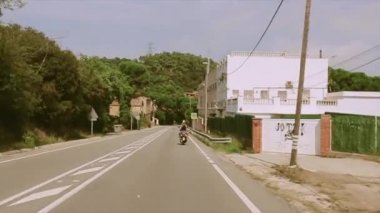 Arka yüzünde iki kişi motosiklet yolda binmek. Birçok yeşil ağaçlar. Seyahat. Yaz güneşli gün