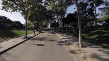 Road şehirde sokak yeşil ağaçları ile yaz güneşli bir günde görüntüleyin. İnsanlar. Kamera motosiklet sürüş