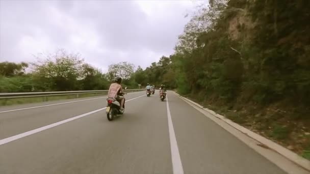 Zadní strana lidí v přilby jezdit na motocykly na silnici mezi kopci plný zelených stromů. Cestování — Stock video