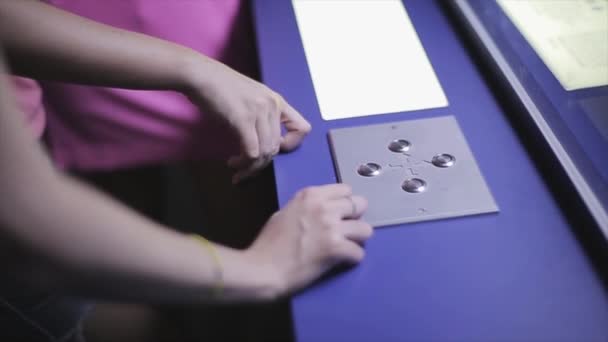 Вид на женщину нажимает зажженные кнопки на панели со стрелками перед окном. Играть. Развлечения — стоковое видео