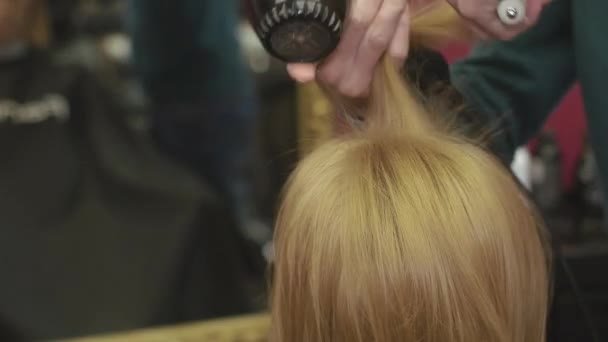 Friseur ziehen Wurzeln von Kopf zu Kopf mit Kamm und Haartrockner im Schönheitssalon. Frisur machen — Stockvideo