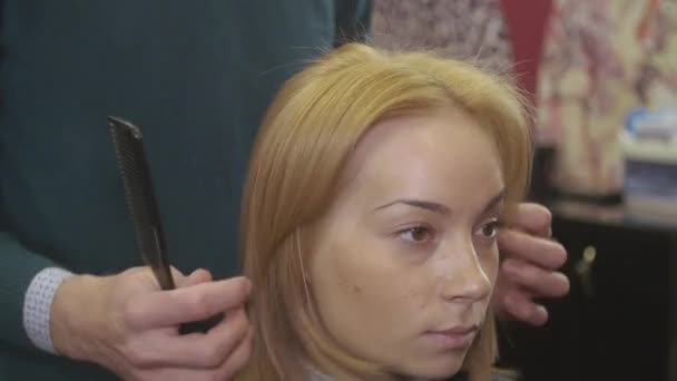 Coiffeur professionnel peigne cheveux à fille par peigne droit dans le salon de beauté. Coiffure volume . — Video