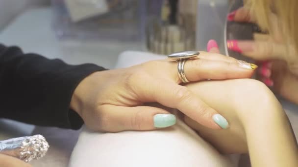 Манікюр подає верхню обкладинку з нігтів жорстким нігтем у салоні краси. Видалення шкіри нігтів — стокове відео