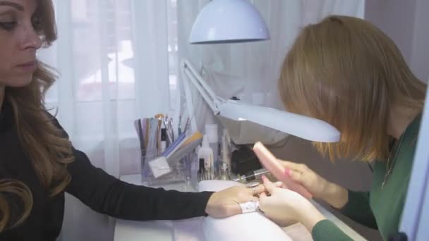 Manicurist fájlt le felső fedelet a körmök a nő a körömreszelő. Shellac-eltávolítás. Használja púderpamacs — Stock videók