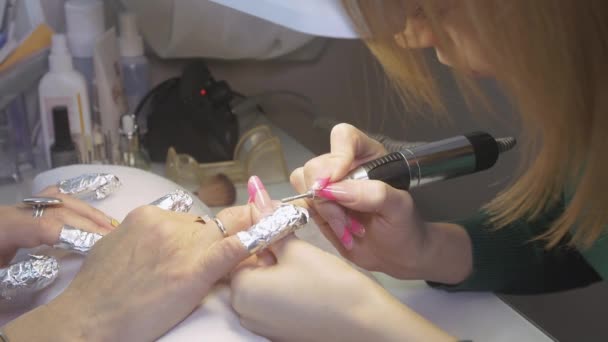 Manicura esmalte superficie uñas a la mujer a mano aparato de uñas en salón de belleza. Manicura de hardware — Vídeo de stock