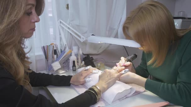 Manicurist polish surface nails to attractive woman by nail apparatus in saloon. Hardware manicure — Stock Video
