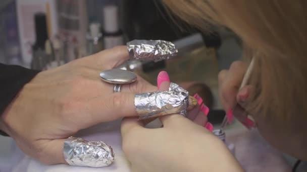 Professional manicurist put white lacquer on designed nails by brush in beauty saloon. Correction — Stock Video