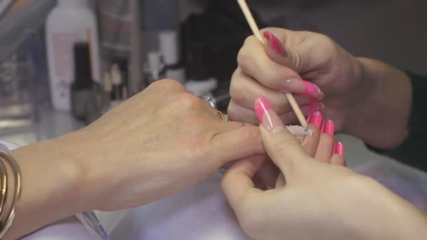 Профессиональный маникюр отложил ногтевую обложку для женщины в салоне красоты с помощью оранжевой палки. Поправка — стоковое видео
