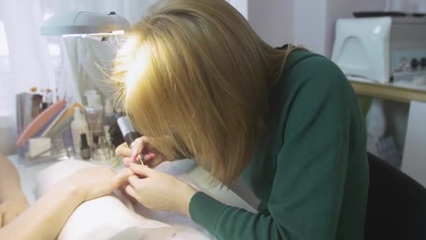 La manicura quitan la tapa de las uñas de la mujer adulta en el salón de belleza por el aparato. Manicura de hardware — Vídeos de Stock