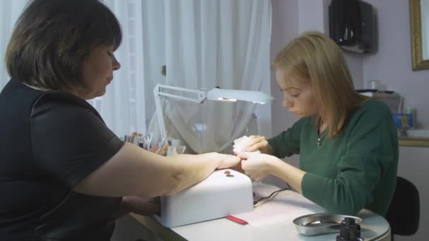 Νύχια θεραπεία επαγγελματική manicurist ενήλικης γυναίκας, με πετσέτα στο σαλόνι ομορφιάς, πριν από Εφαρμόστε κάλυμμα. — Αρχείο Βίντεο