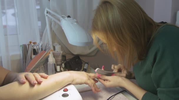 Nail master correct shape of nails to client in beauty saloon by curved nail file. Classic manicure — Stock Video