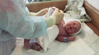 Doğumdan sonra Ağlayan bebek bezli üzerinde tek kullanımlık çocuk bezi koymak hemşire. Doğum Hastanesi.