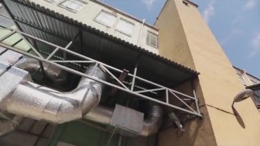 Sarı endüstriyel modern bina büyük borularla görünümünü. Büyük pencereler. Yaz güneşli gün