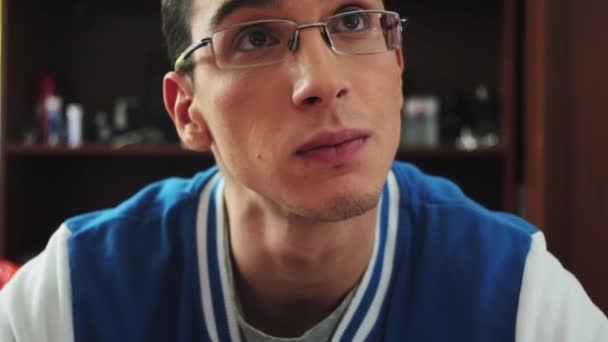 Ritratto di giovane ragazzo in occhiali sguardo serio sullo schermo. Guardati intorno. Di 'qualcosa. Studente . — Video Stock