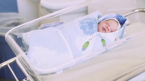 刚出生的婴儿眯着眼睛从夏时制，打呵欠躺在尿布，蓝色毯子的妇产科医院. — 图库视频影像