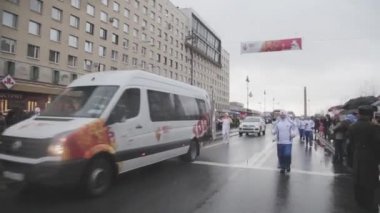 Saint Petersburg, Rusya - 27 Ekim 2013: bayrak yarışı Sochi Saint Petersburg'daki Olimpiyat meşalesinin. Koş, ışık tutan kimse diğerine geçişi yangın. Konvoy