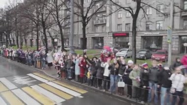 SAINT PETERSBURG, RUSSIA - OCTOBER 27, 2013: Crowd of people wave flags, hands in camera, smile. Camera inside moving bus. October