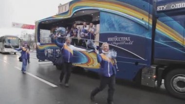 SAINT PETERSBURG, RUSSIA - OCTOBER 27, 2013: Walking people, youth in bus wave pompons. Relay race of Sochi Olympic flame in Saint Petersburg