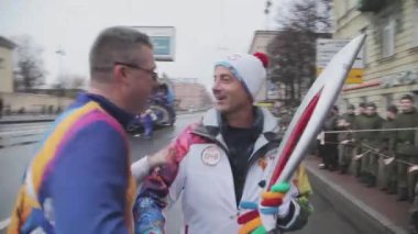 Saint Petersburg, Rusya - 27 Ekim 2013: St. Petersburg'da Soçi Olimpiyat meşalesi bayrak yarışı. Üniformalı adam meşale taşıyıcısına el sıkışmak verir