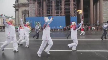 Saint Petersburg, Rusya - 27 Ekim 2013: St. Petersburg'da bayrak yarışı Sochi Olimpiyat meşalesi. Üniformalı meşale taşıyıcıları. Isaac Katedrali