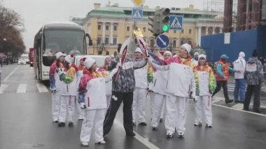 Saint Petersburg, Rusya - 27 Ekim 2013: St. Petersburg'da bayrak yarışı Sochi Olimpiyat meşalesi. Meşale taşıyıcısı üniforma transfer alev. Dalga el
